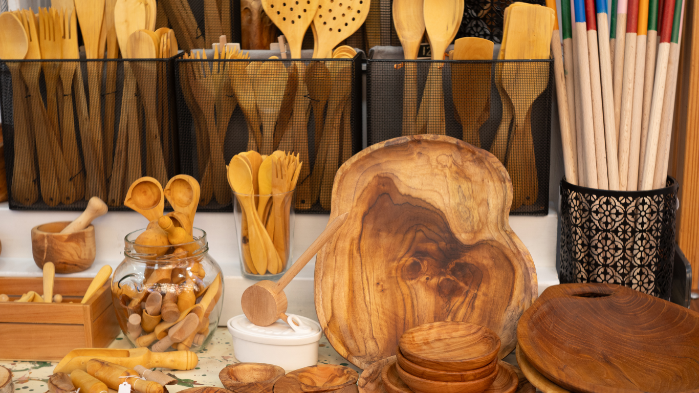Wooden kitchen utensils and serving platters displayed for sale.