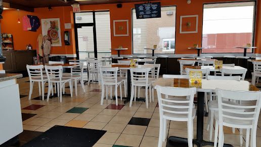 The inside of a restaurant with tables and chairs.