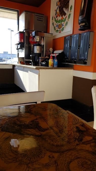 A restaurant with a table and chairs and a coffee machine.