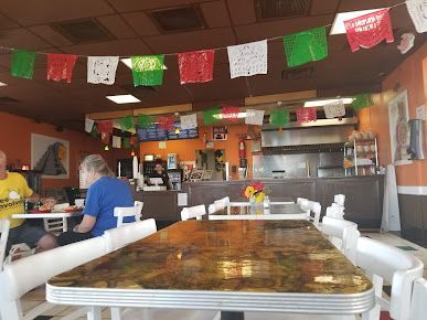 A man is sitting at a table in a restaurant.