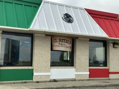 A brick building with a red , green and white roof.