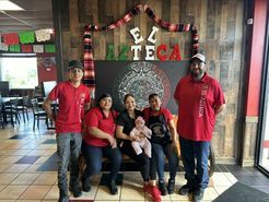 A group of people are posing for a picture in a restaurant.