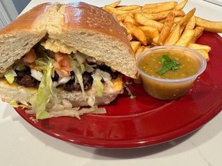 A sandwich and french fries are on a red plate.