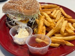 A red plate topped with a hamburger and french fries.