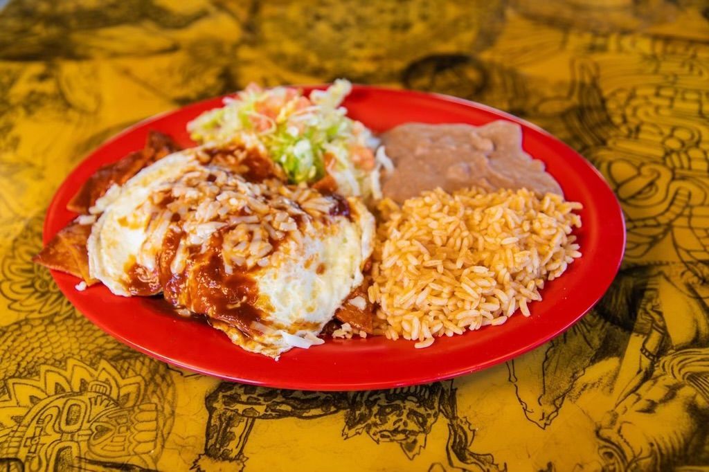 A plate of mexican food with rice and beans on a table.