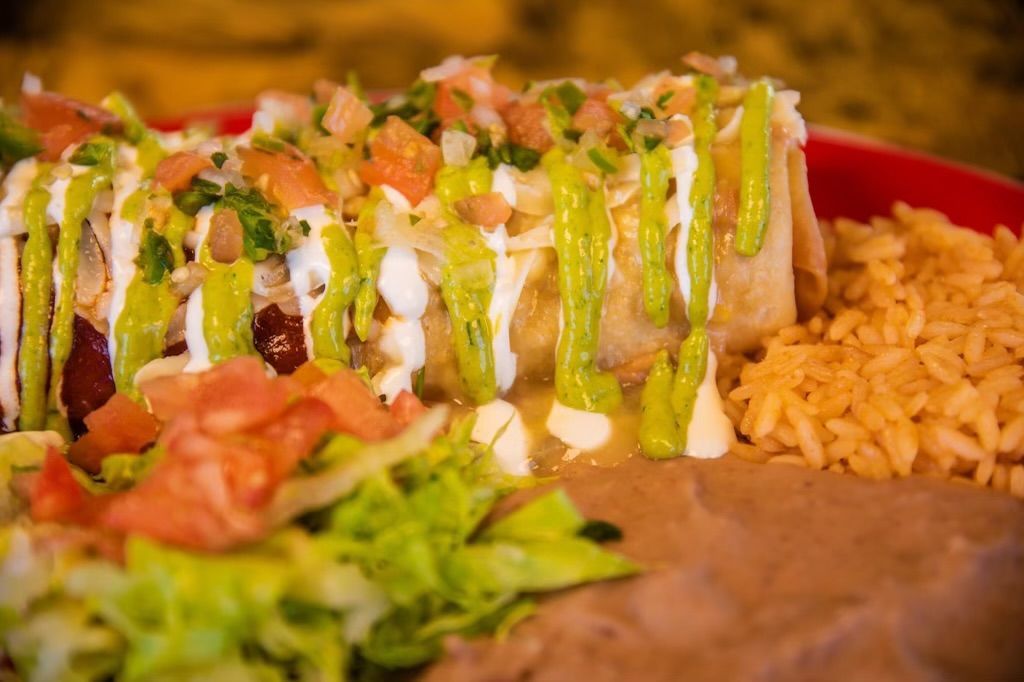 A close up of a plate of mexican food with rice and beans.