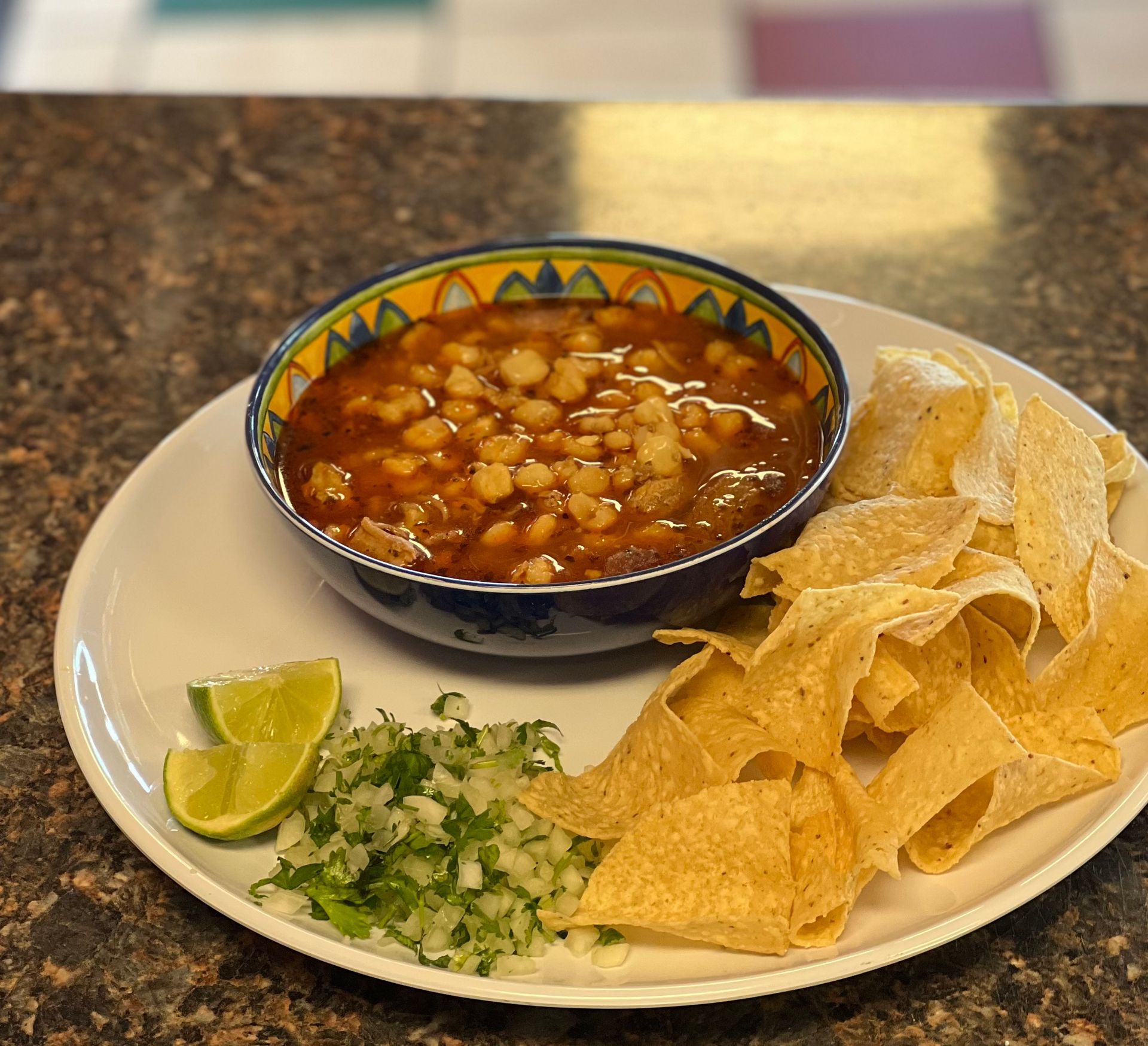 A plate of food with a bowl of soup and tortilla chips