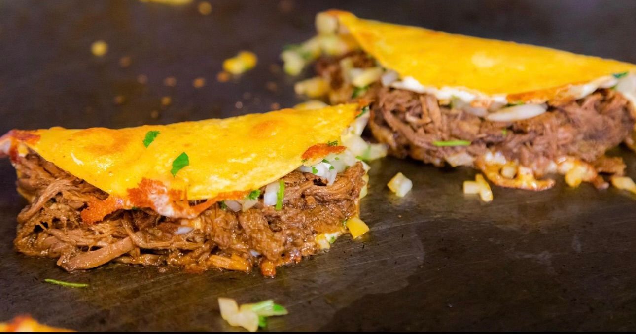 Two tacos are being cooked on a grill.