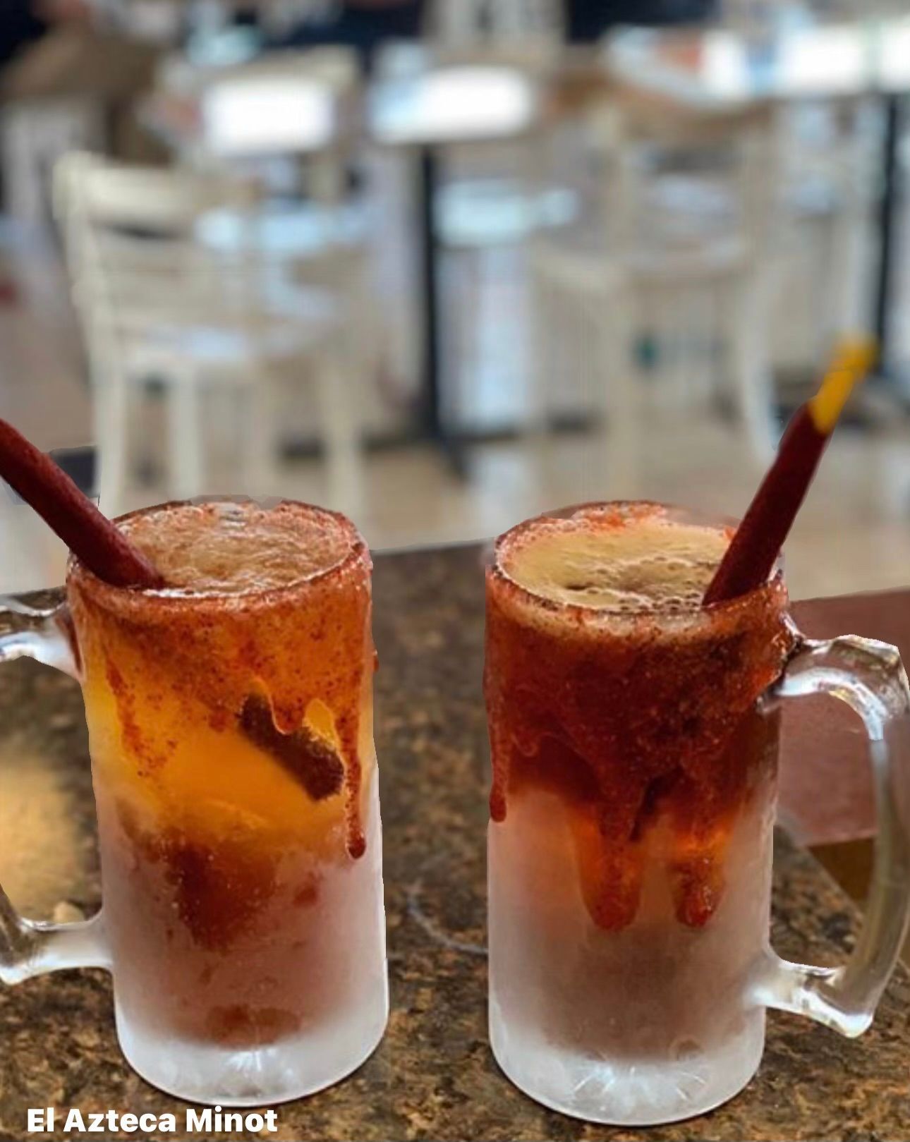 Two drinks with straws in them are sitting on a table.