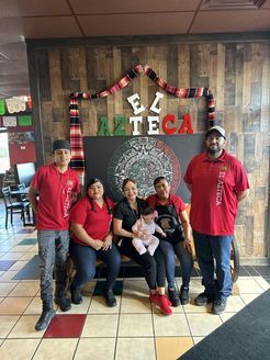 A group of people are posing for a picture in a restaurant.