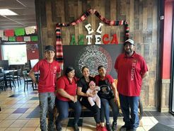A group of people are posing for a picture in a restaurant.