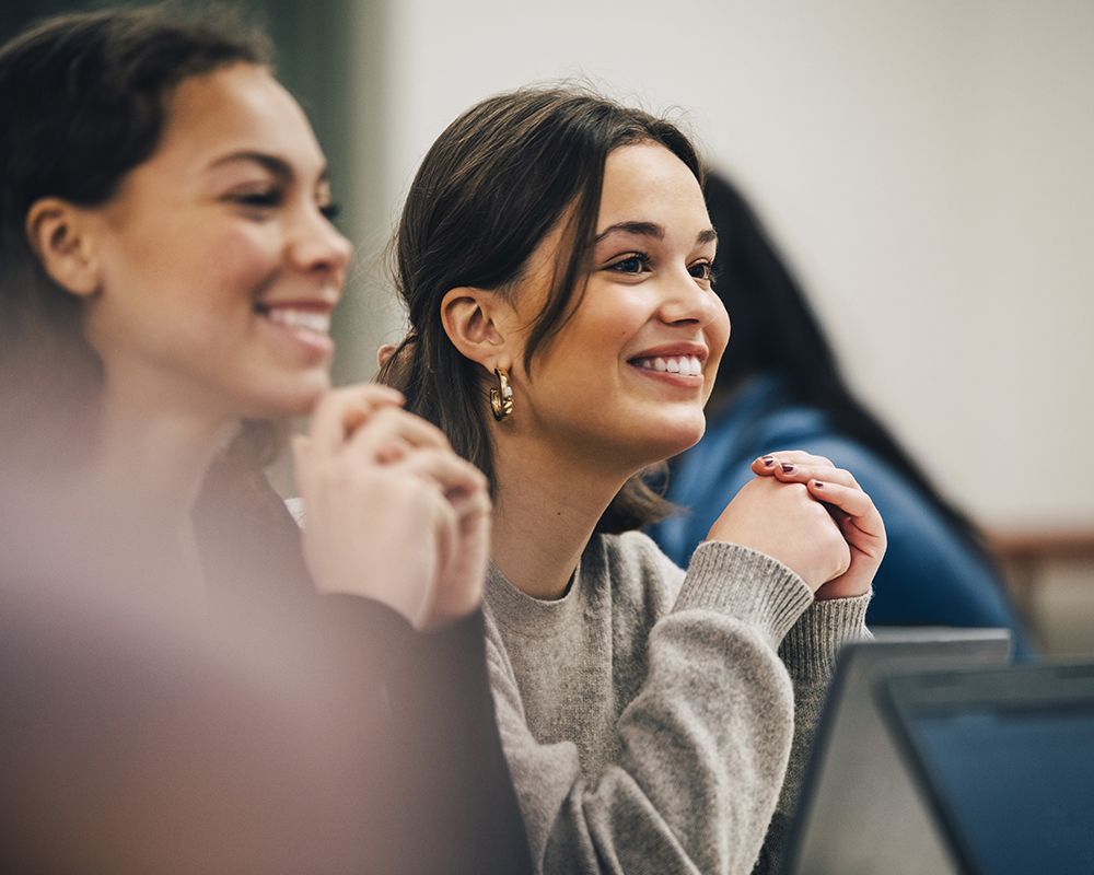 due giovani donne sono sedute a un tavolo e sorridono
