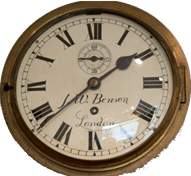 Antique wall clock with Roman numerals, brass bezel, and black hands on a white background.