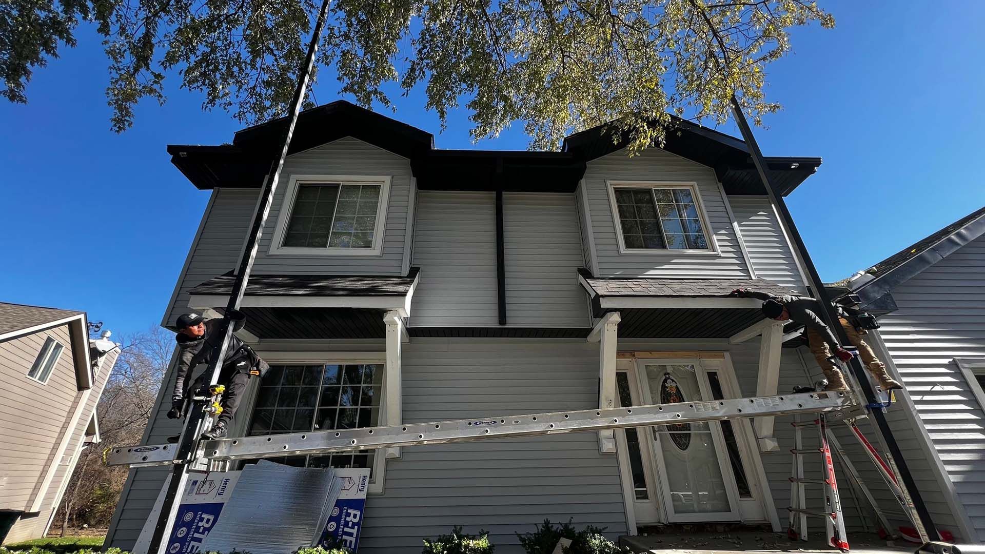 A house is being painted with a ladder attached to it