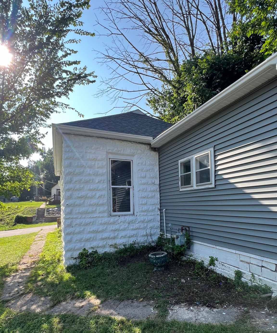 A gray house with a white shed on the side of it