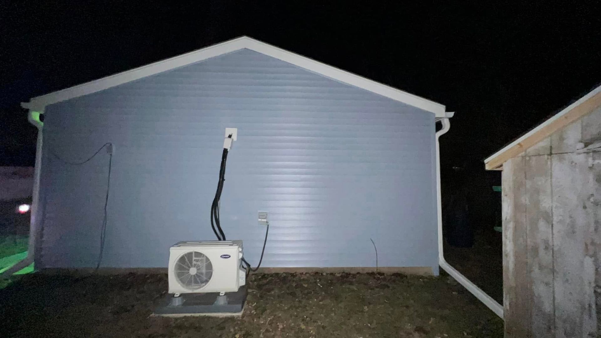 A house with a fan on the side of it at night