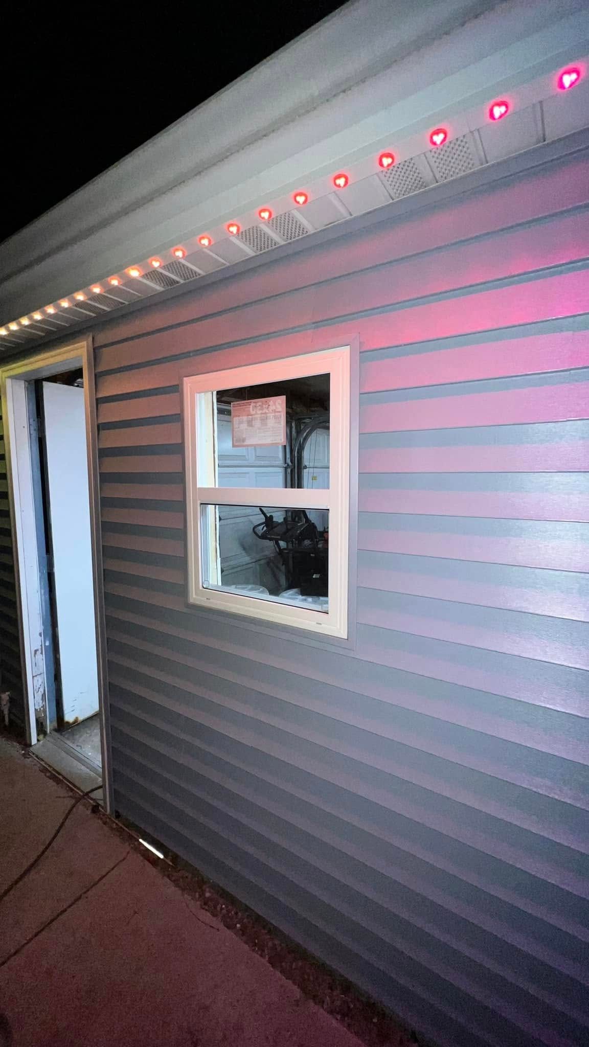 A house with a window and christmas lights on the side of it
