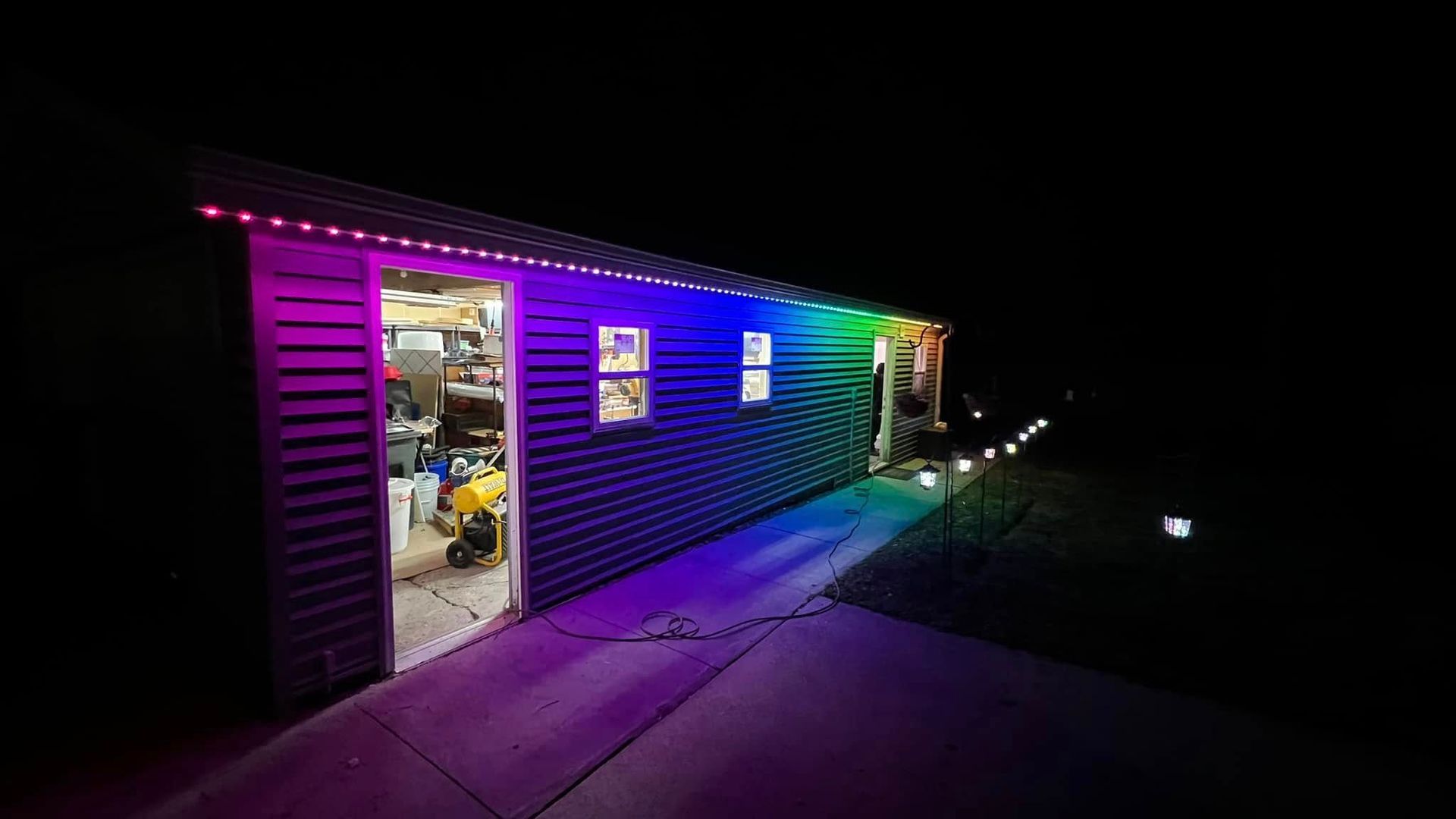A garage with a rainbow of lights on it at night