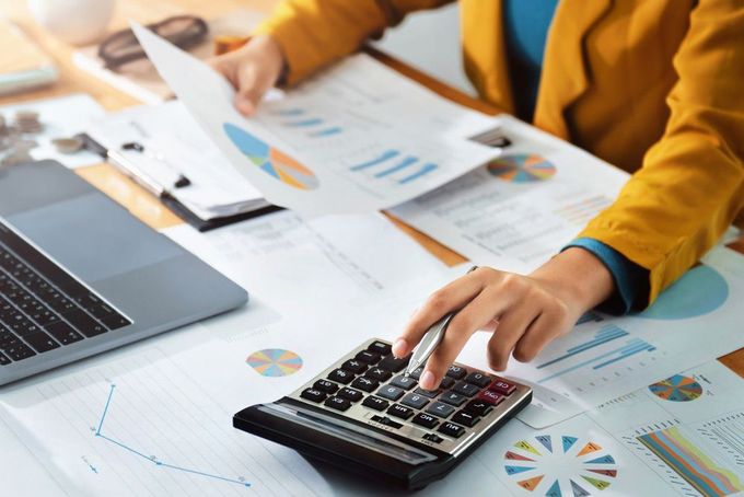 A Person is Using a Calculator While Holding a Piece of Paper — D&T Accounting & Bookkeeping In Umina Beach, NSW