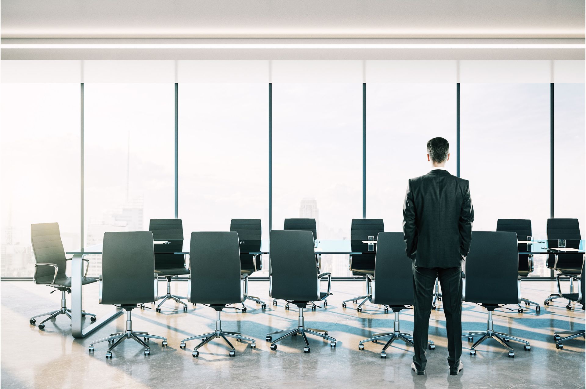 A man in a suit is holding a notebook and smiling.