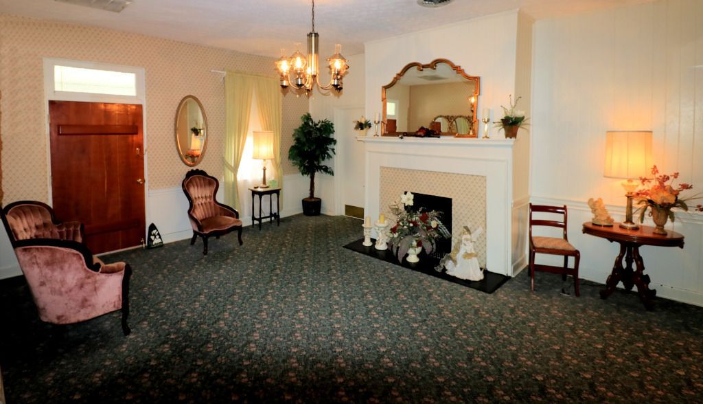 A living room with a fireplace and chairs in it at Foster-Toler-Curry Funeral Home