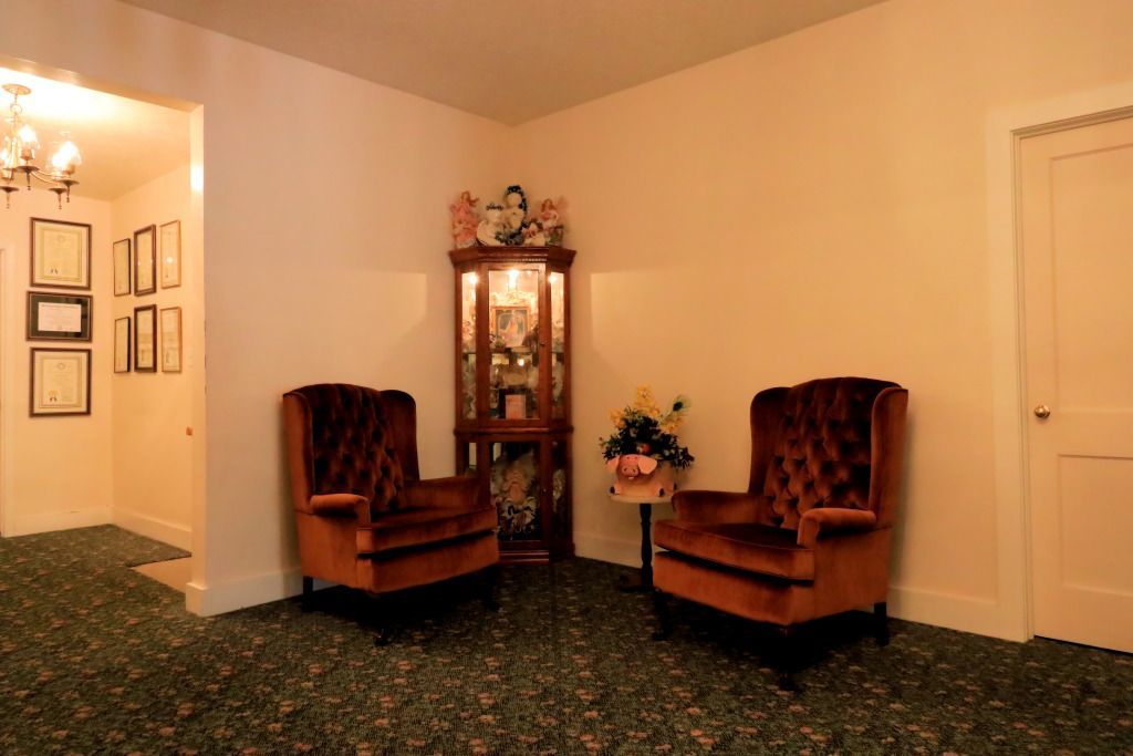 A living room with two chairs and a display case