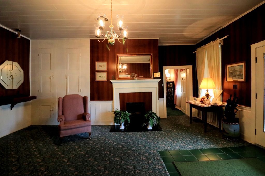 A living room with a fireplace and a chair Foster-Toler-Curry Funeral Home