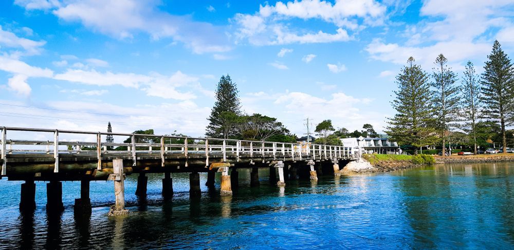 A Bridge Over a Body of Water With Trees in the Background — Water Please In Brunswick Heads, NSW