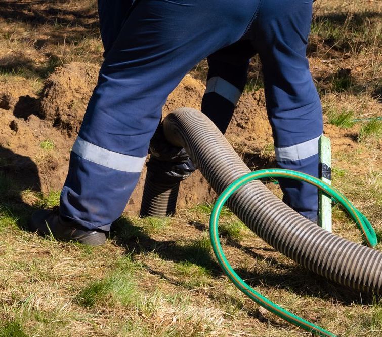 A Man in Blue Pants is Standing Next to a Green Hose — Water Please In Ocean Shores, NSW
