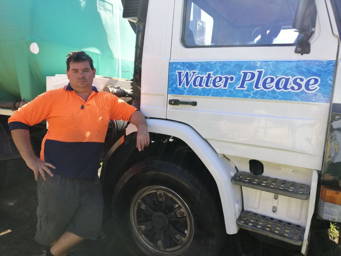 A Man Standing Next to a Water Please Truck — Water Please In Bangalow, NSW