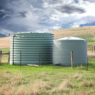 Two Water Tanks in A Grassy Field with A Fence in The Background — Water Please In Alstonville, NSW