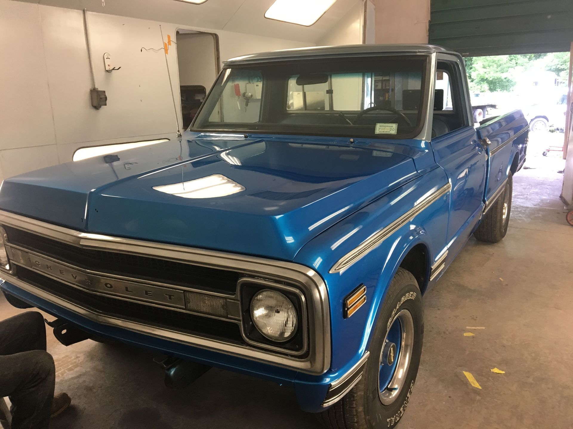 A blue pickup truck is parked in a garage.