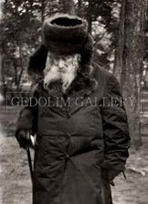 A black and white photo of a man with a beard wearing a fur hat and holding a cane.