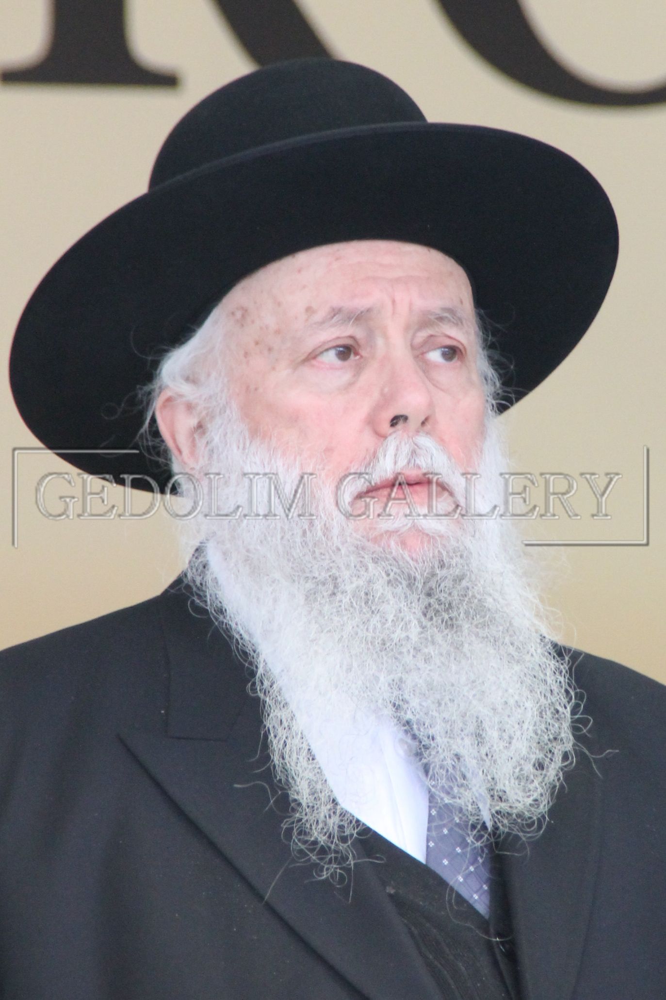 A man with a long beard wearing a black hat