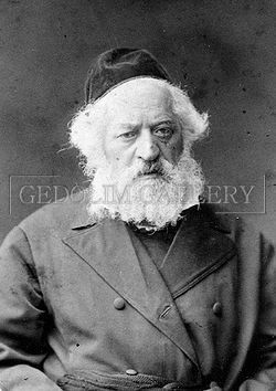 A black and white photo of a man with a beard and a hat.