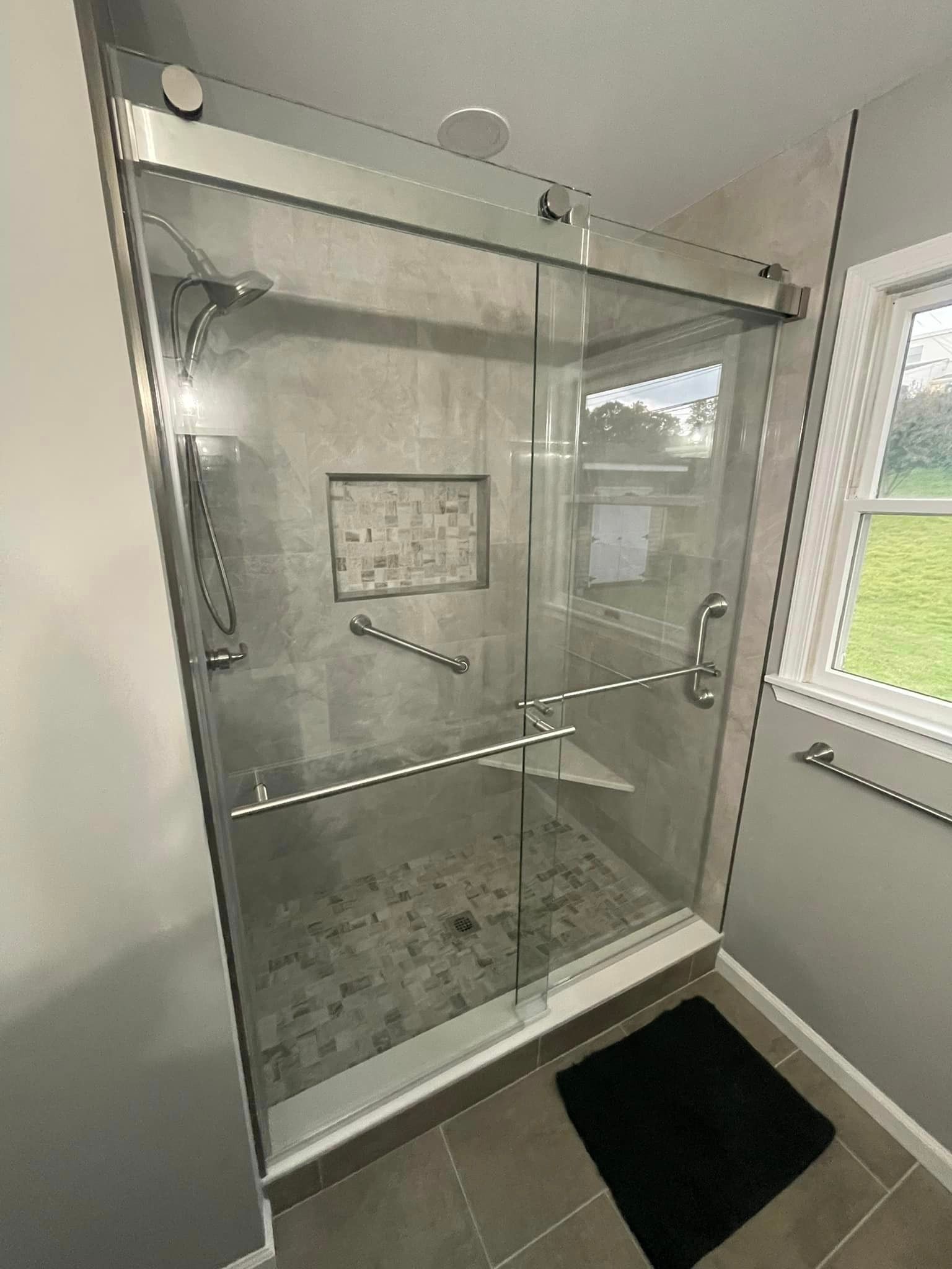 stand up fully tiled shower enclosed with custom glass doors