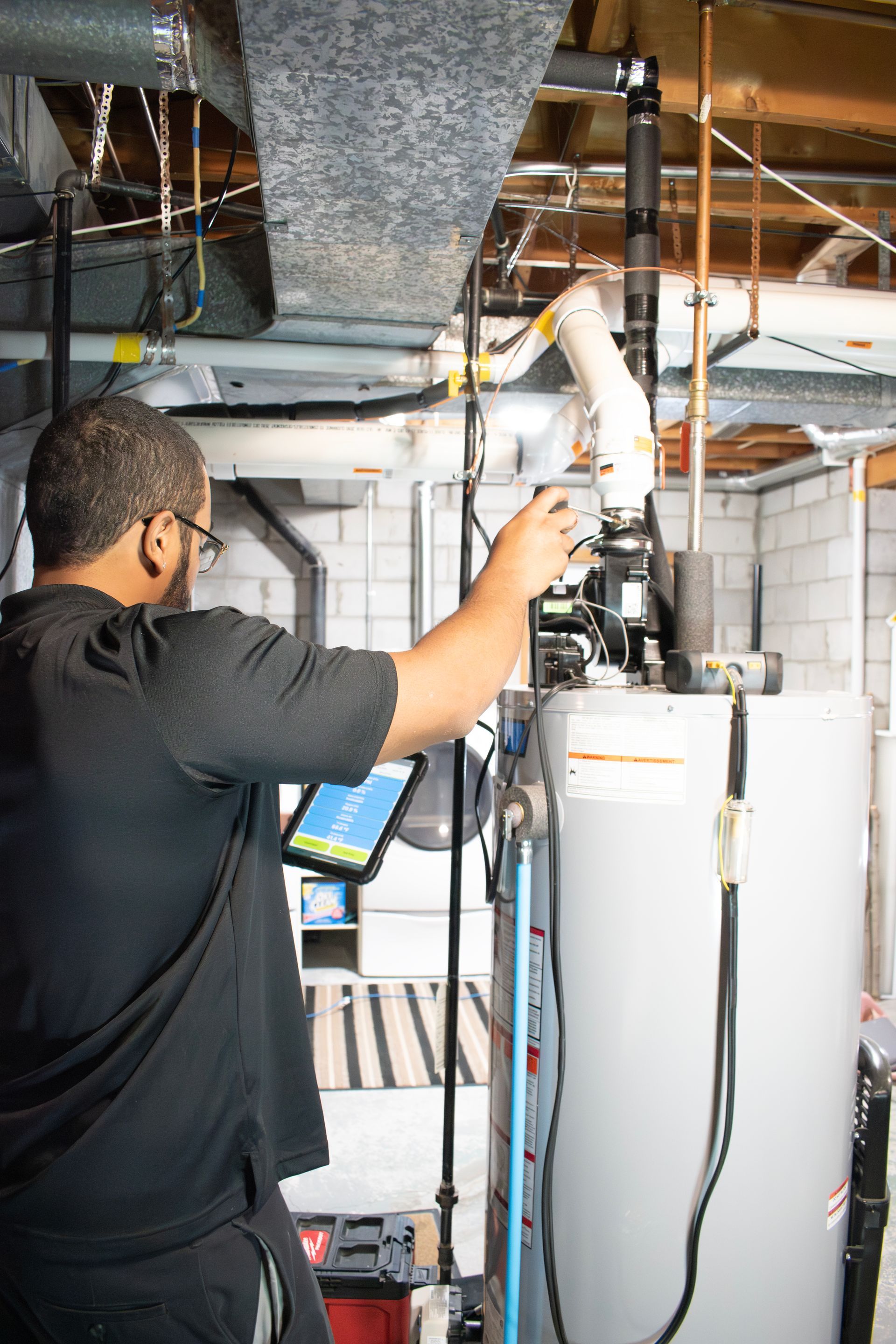 Licensed technician servicing a residential water heater to ensure safe and reliable hot water