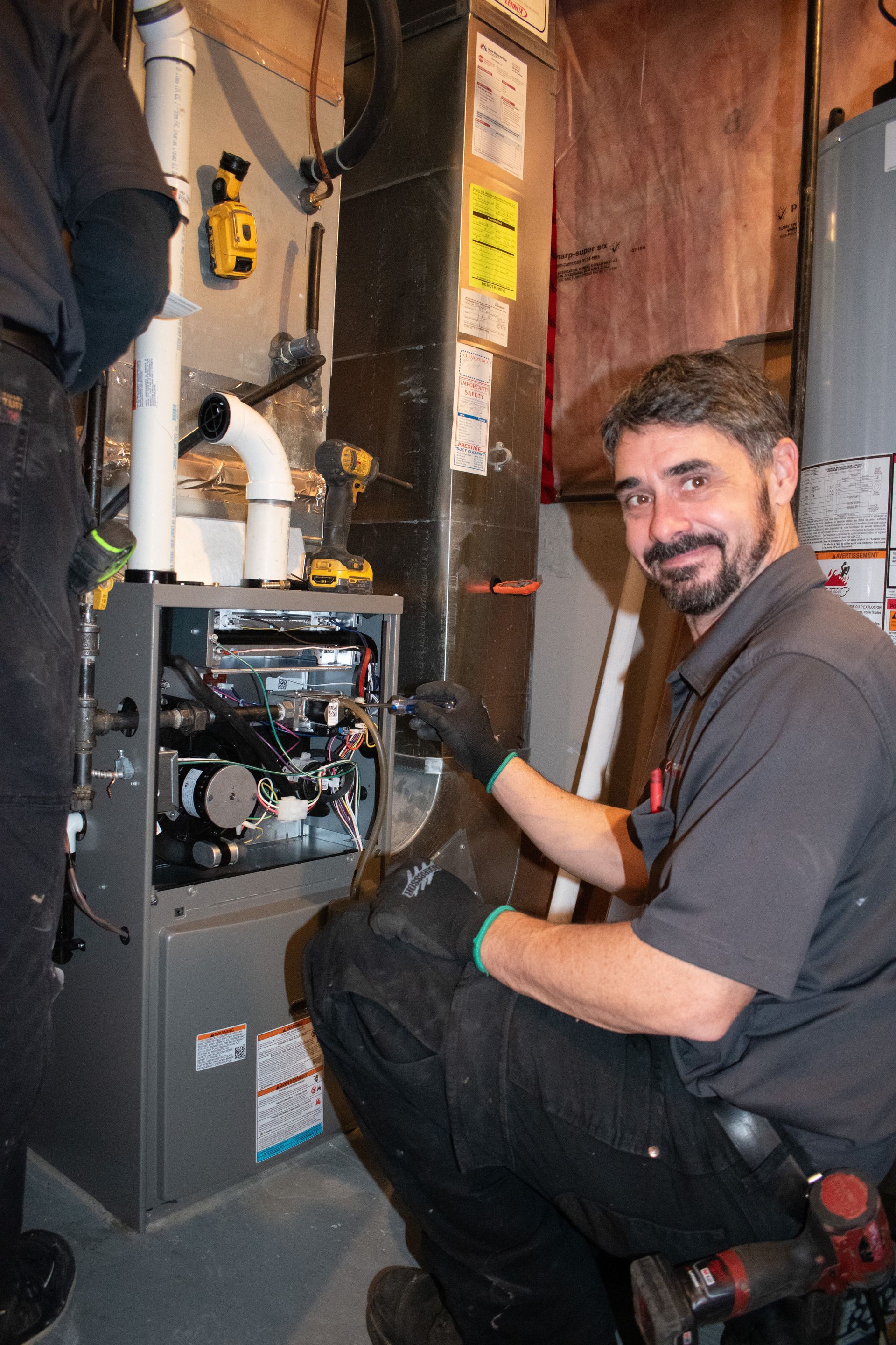 HVAC technician inspecting a residential furnace during a service visit