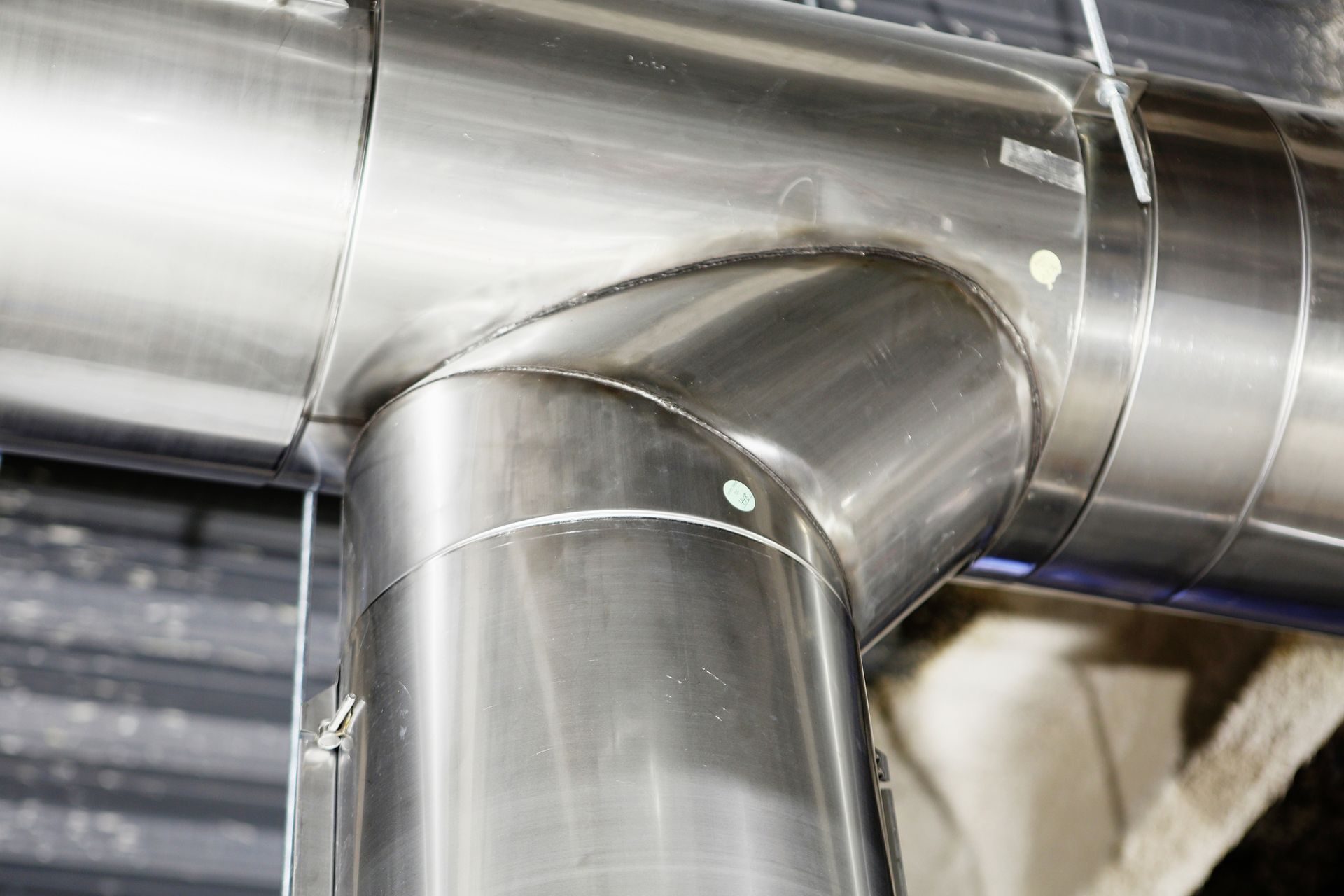 A close up of a stainless steel pipe in a building.