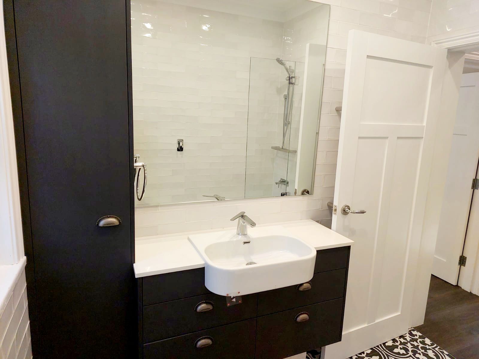 Modern Bathroom With Dark Gray Vanity, White Sink, Large Mirror, and Black Storage Cabinet  — Elimar Construction in Goulburn, NSW