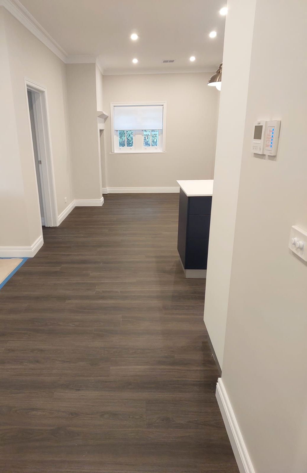 Interior View of a Room With Dark Wood Flooring, Light Walls, and a Kitchen Island  — Elimar Construction in Goulburn, NSW