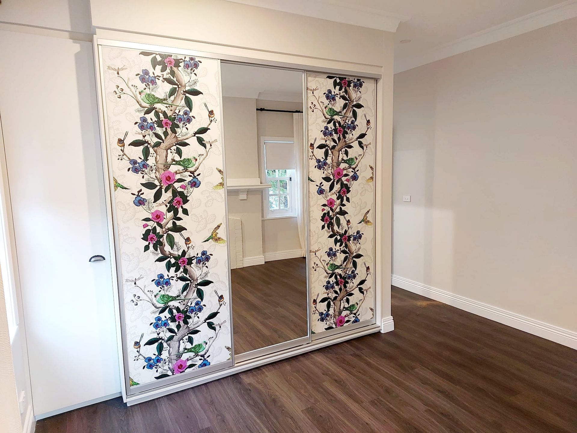 Bedroom With Floral Sliding Closet Doors and Wood Floors  — Elimar Construction in Goulburn, NSW