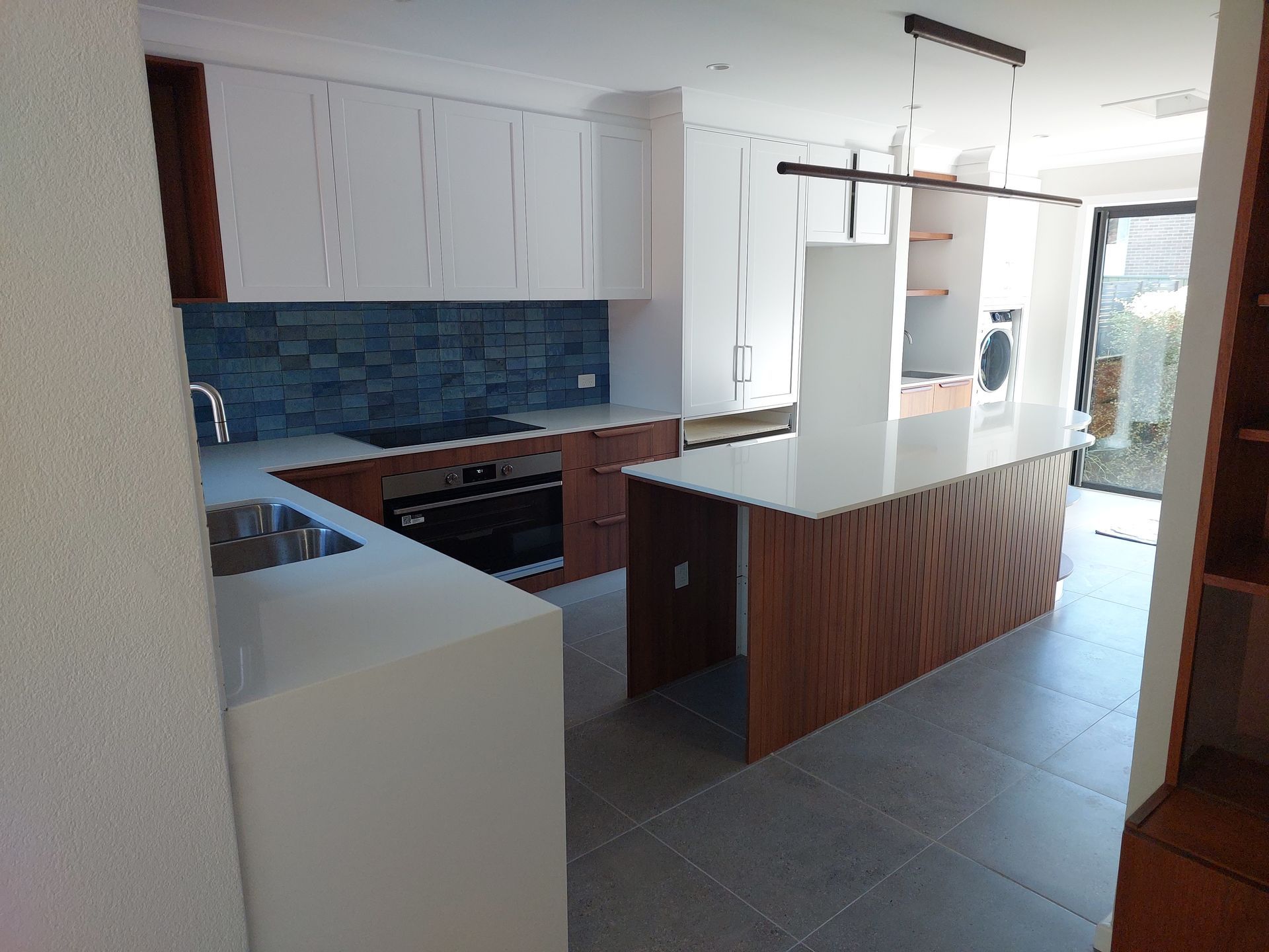 Modern Kitchen With White Cabinetry, Wood Accents, and a Large Island — Elimar Construction in Goulburn, NSW
