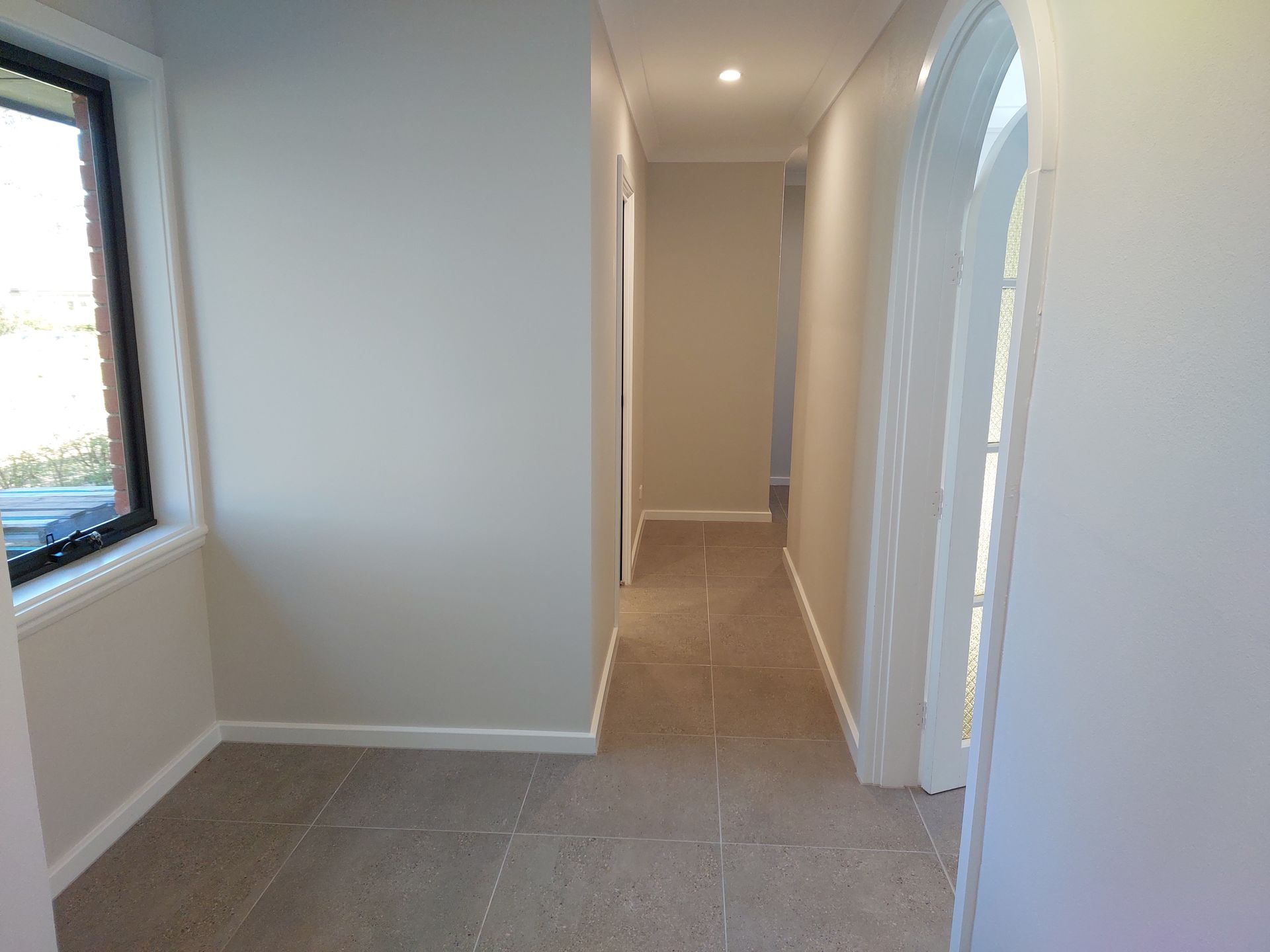 Narrow Hallway With Tile Floor and Off-white Walls. Doorways and a Window Are Visible — Elimar Construction in Goulburn, NSW