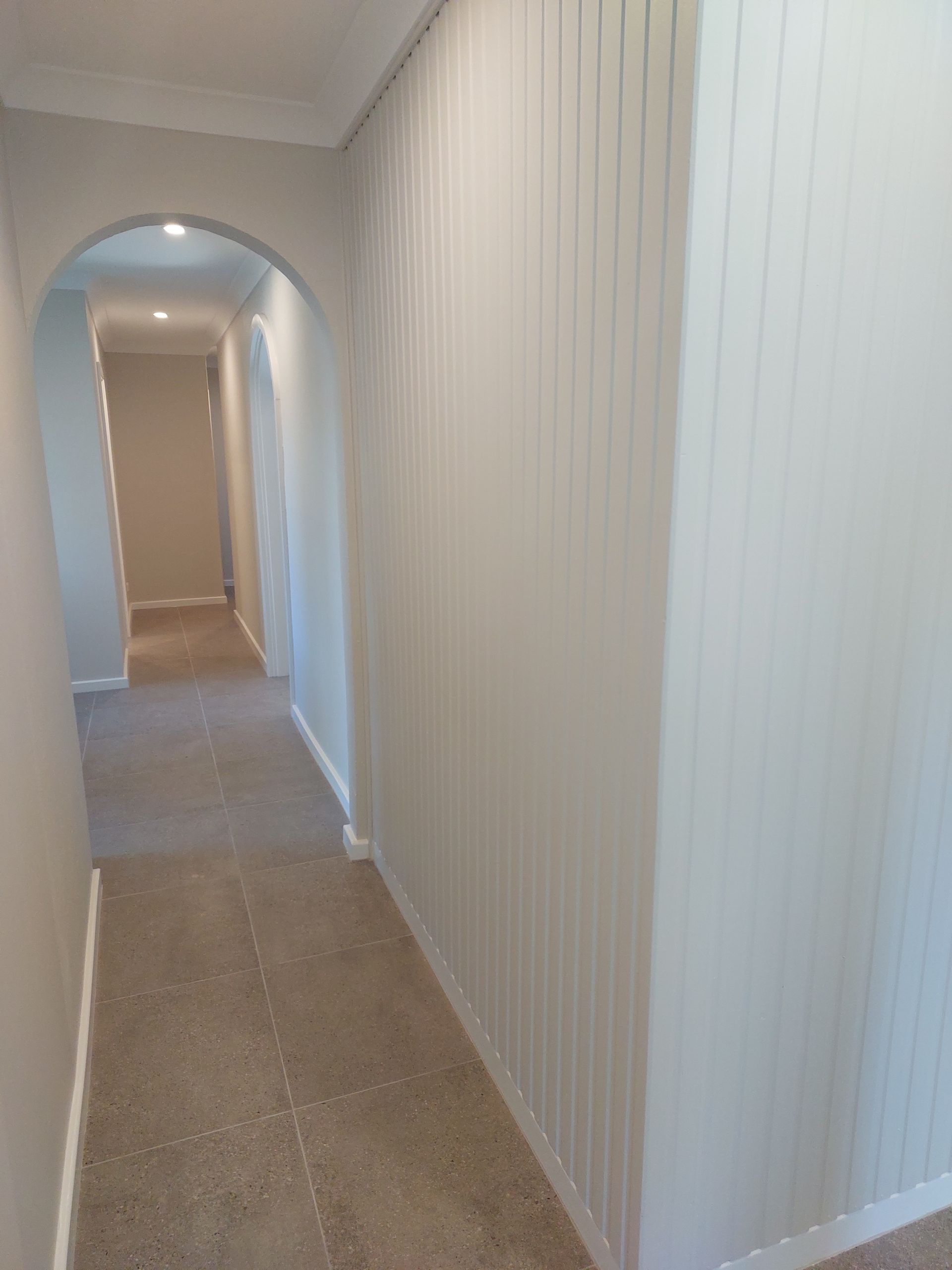 Hallway With Beige Carpet, White Paneled Wall, Archway, and Neutral-colored Walls — Elimar Construction in Goulburn, NSW
