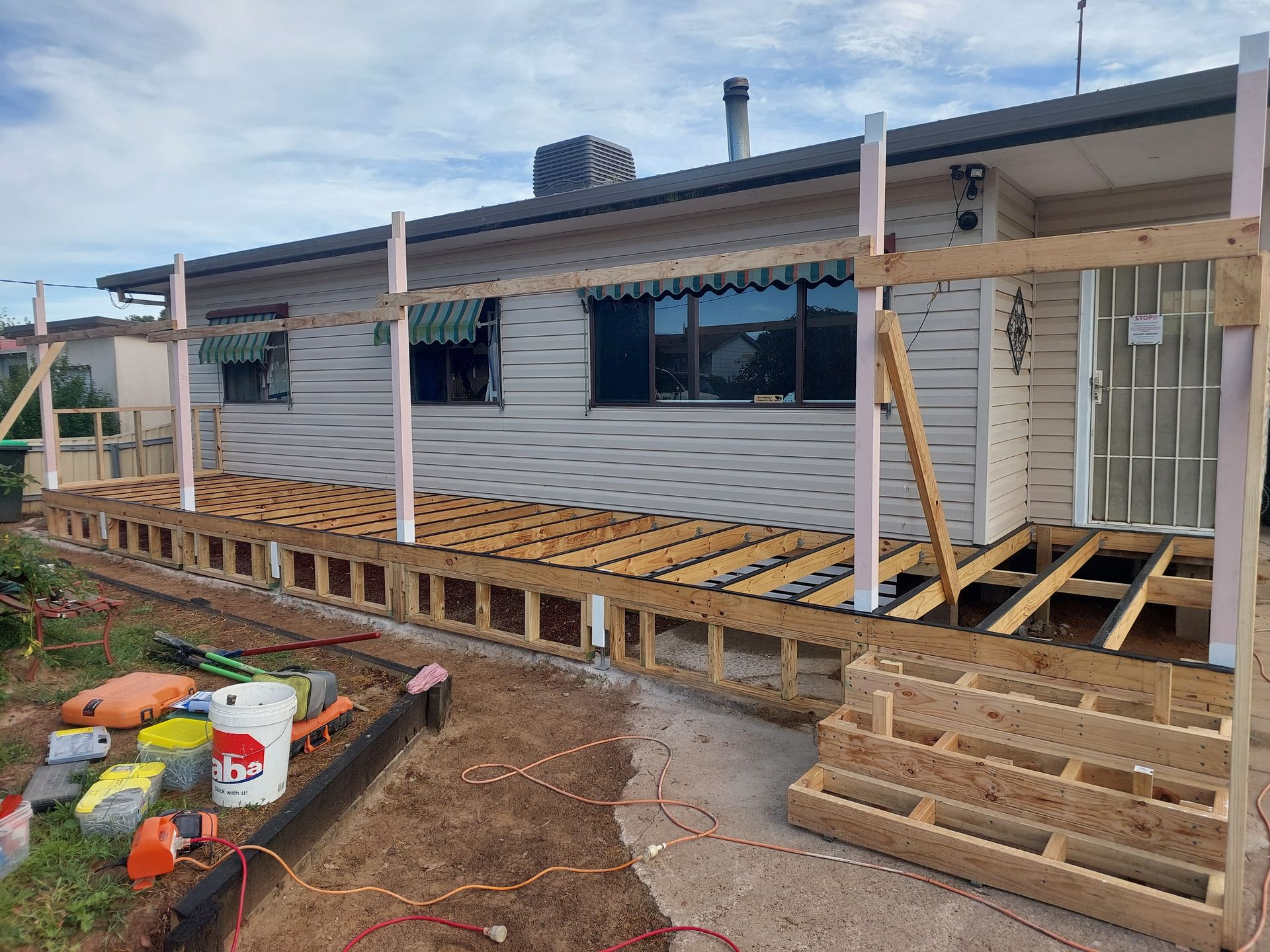 A House With a Wooden Deck Being Built in Front of It — Elimar Construction in Goulburn, NSW