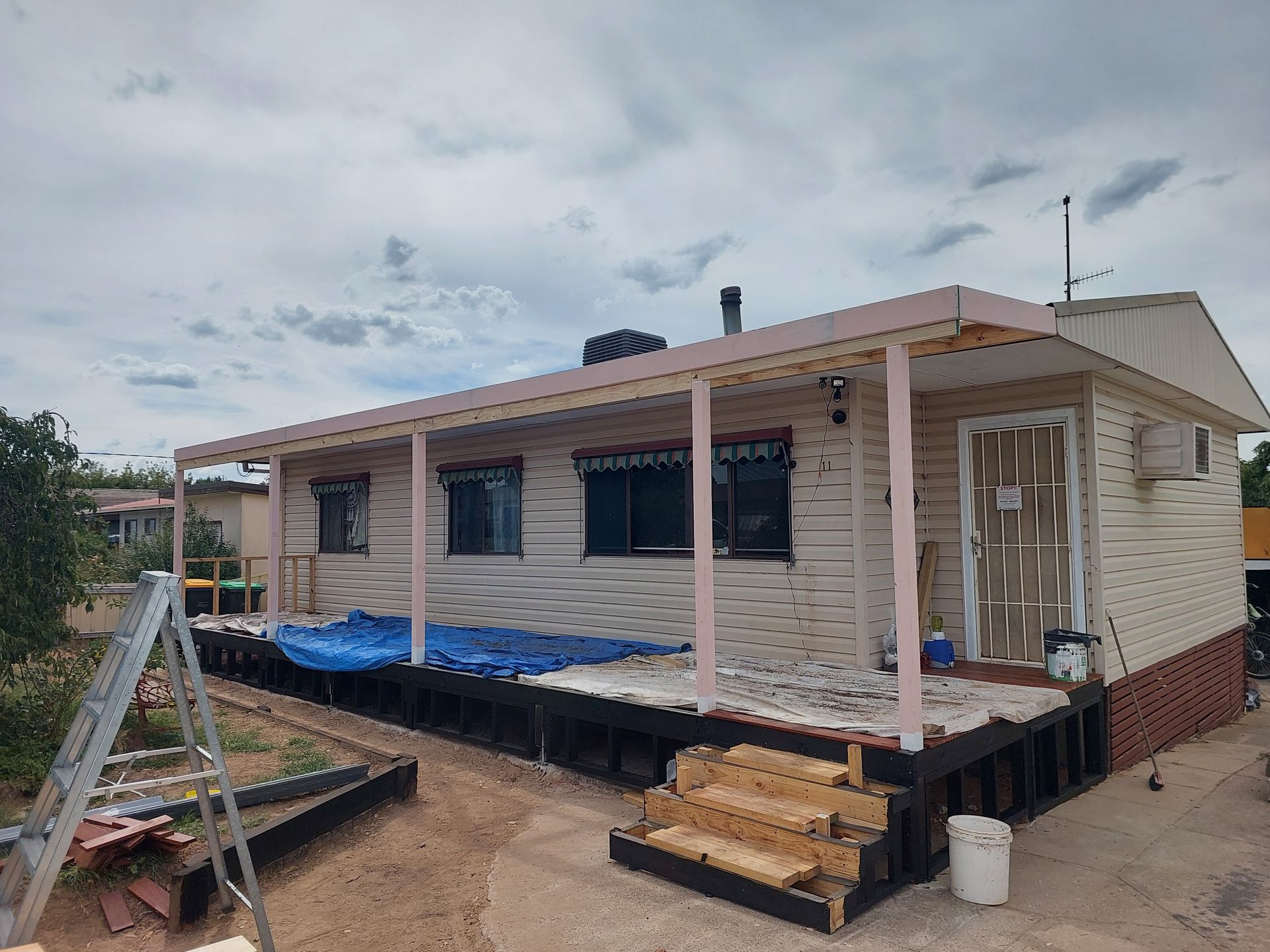 A House With a Porch and Stairs is Being Painted — Elimar Construction in Goulburn, NSW