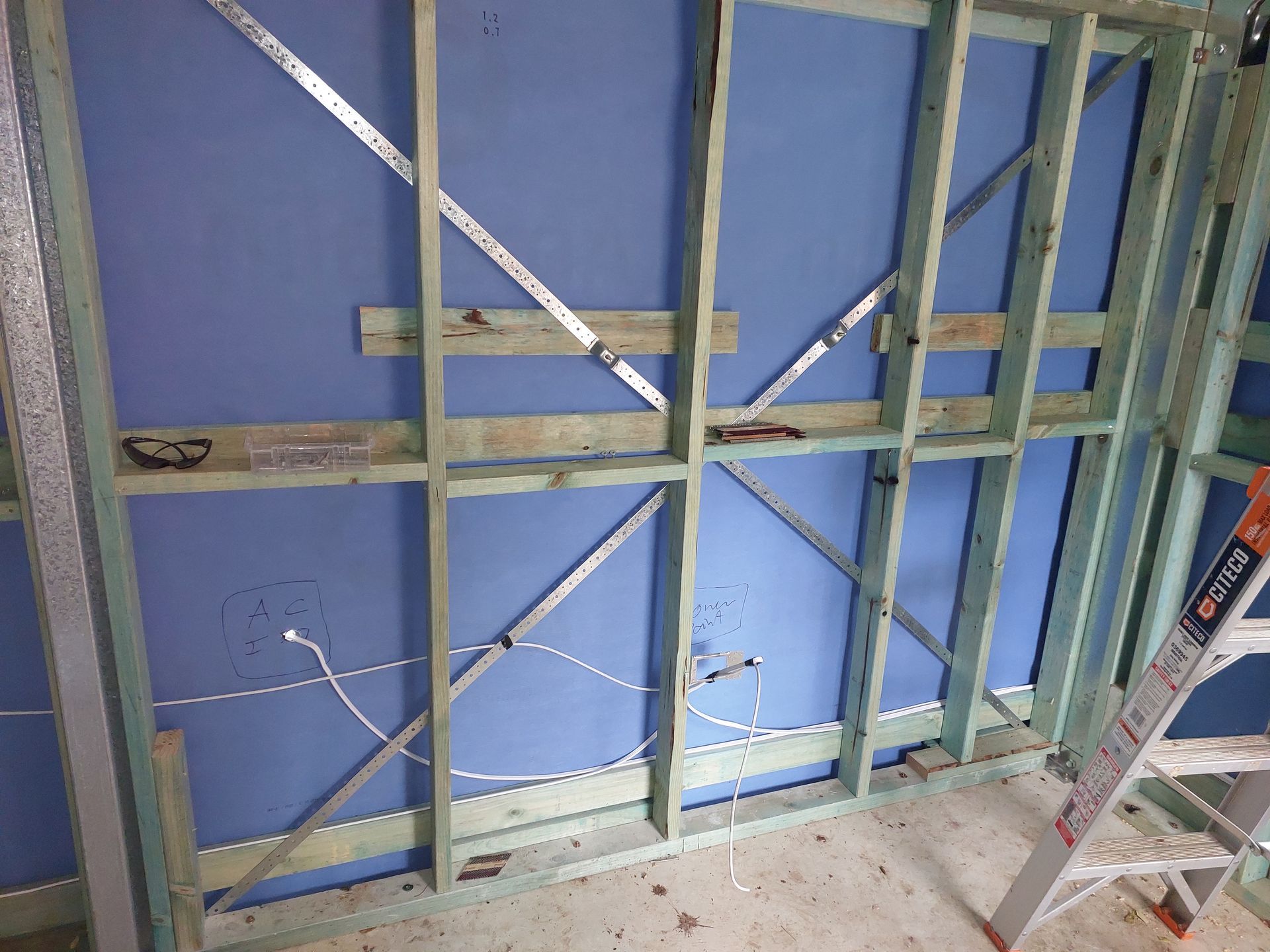 Interior Wall Under Construction; Wooden Frame, Blue Wall, Electrical Wires, Ladder in Corner — Elimar Construction in Goulburn, NSW