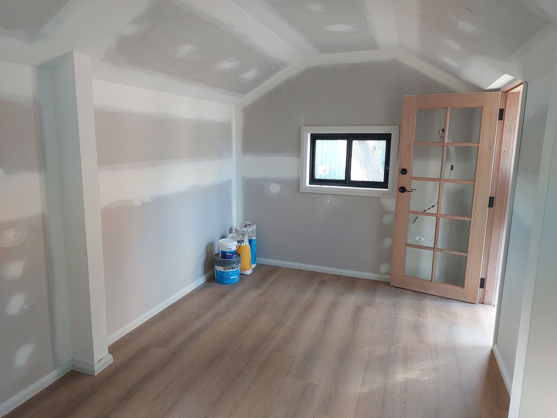 Interior Room With Drywall, Arched Ceiling, Wooden Floor, Door With Glass Panels, and Window — Elimar Construction in Goulburn, NSW