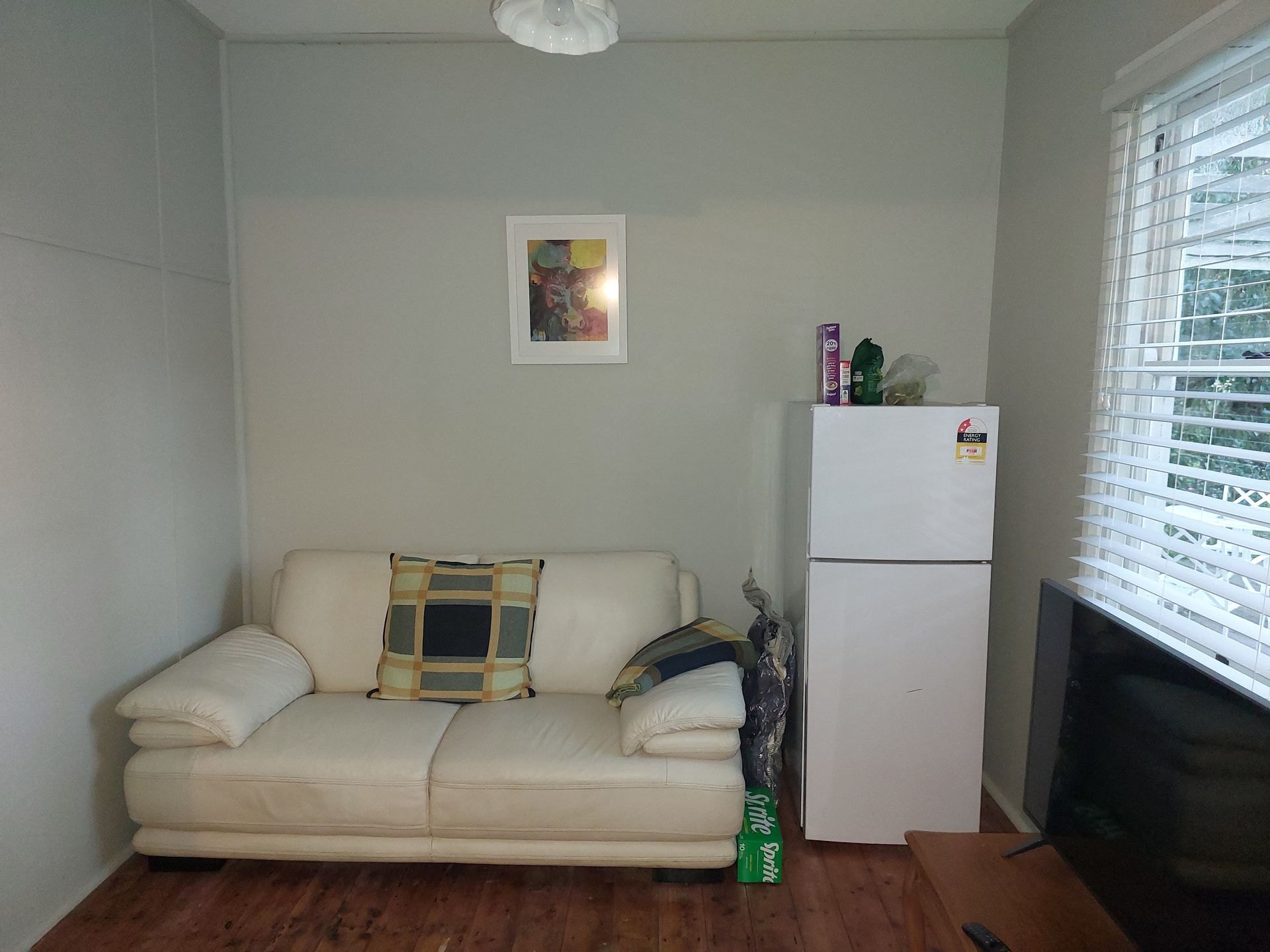 A Living Room With a Couch, Refrigerator and Television — Elimar Construction in Goulburn, NSW